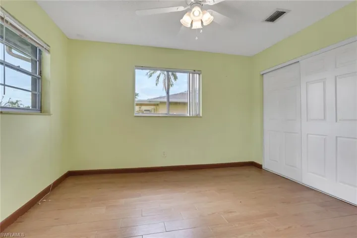 Unfurnished bedroom with light wood-type flooring, a ceiling fan, and a closet