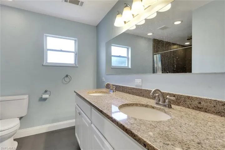 Full bath with double vanity and a shower with curtain