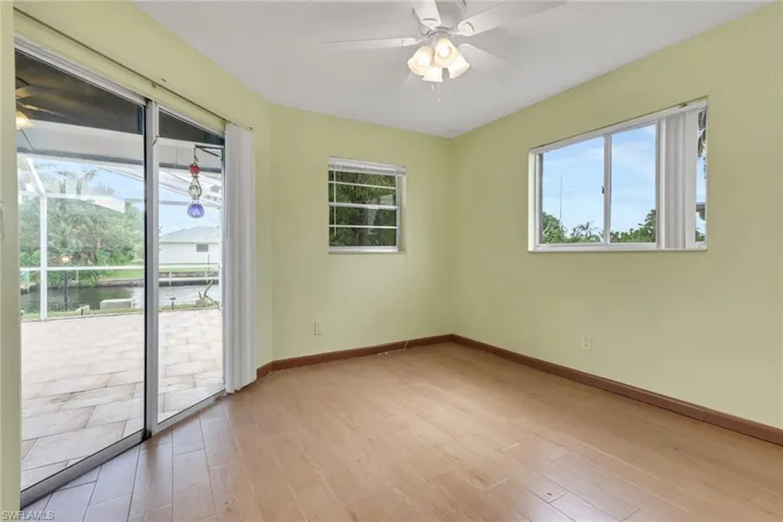 Empty room featuring a ceiling fan, light wood-style floors, and a water view