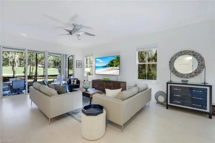 Living room featuring ceiling fan, plenty of natural light, ornamental molding, and light hardwood / wood-style flooring