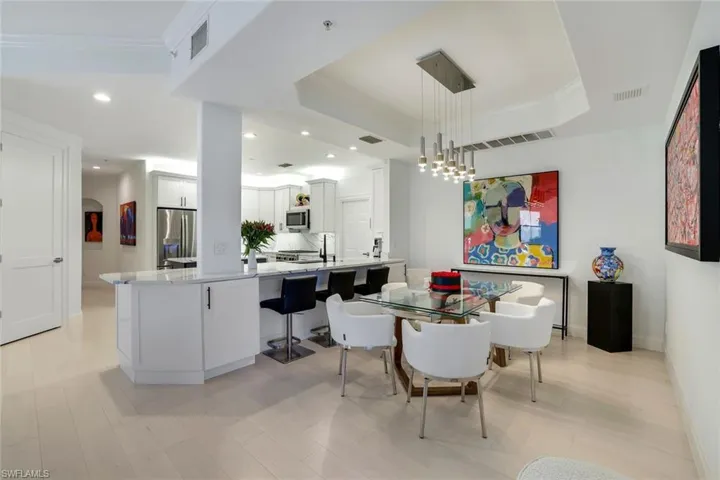 Dining area with an inviting chandelier, ornamental molding, and a tray ceiling