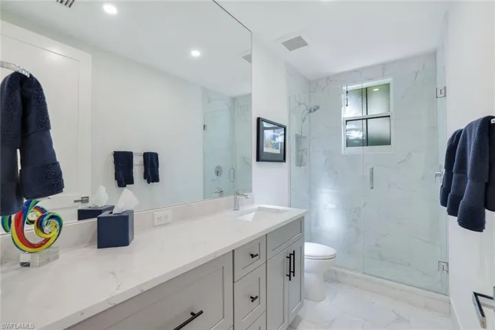 Bathroom featuring vanity, toilet, and walk in shower