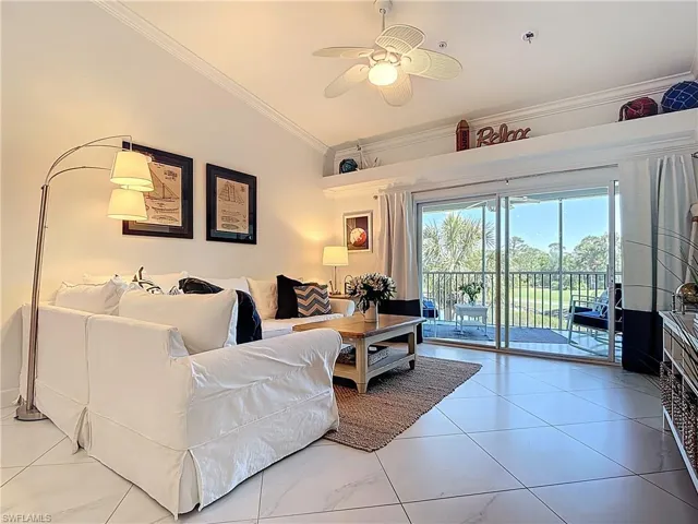 LIVING ROOM WITH SLIDER TO ENCLOSED LANAIN & GORGEOUS VIEW OF GOLF COURSE AND LAKE