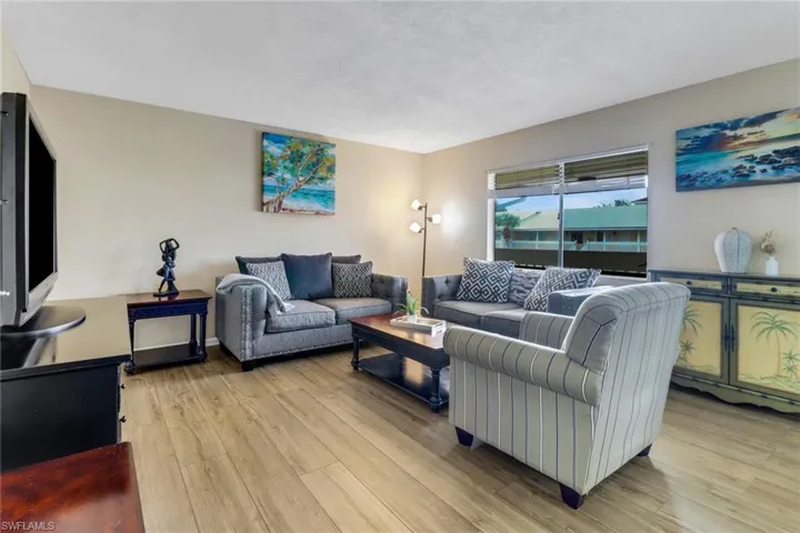 Living room with light wood-type flooring and a textured ceiling