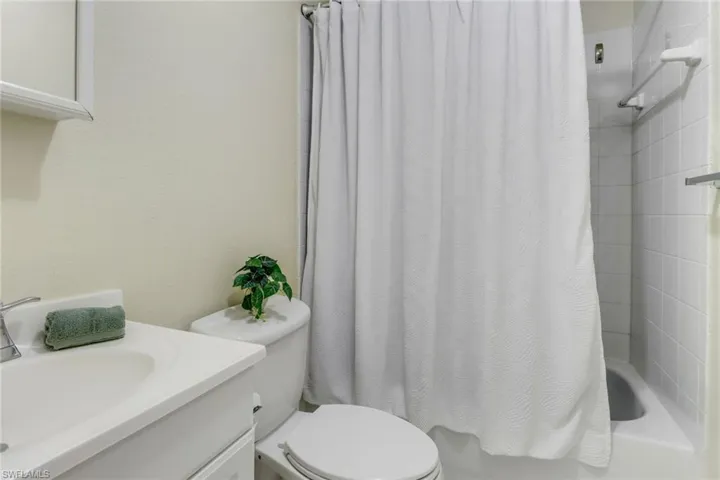 Bathroom featuring shower / bathtub combination with curtain and vanity