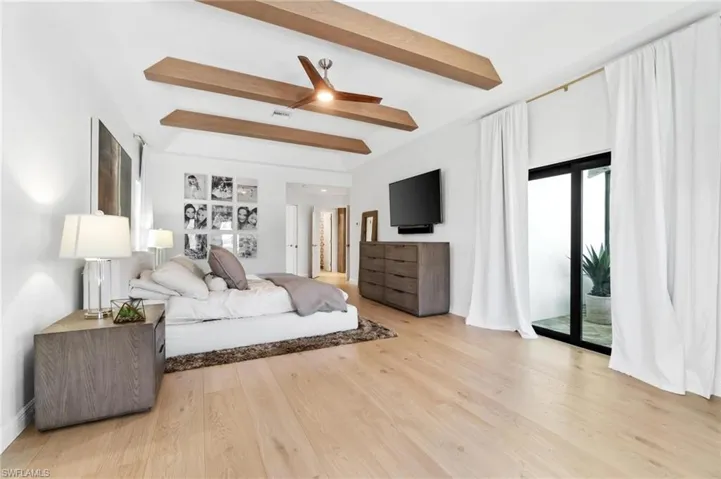Bedroom featuring access to outside, beam ceiling, light wood-style flooring, and ceiling fan