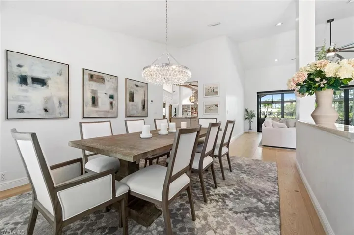 Dining area with light wood-type flooring, lofted ceiling, and suspended lighting