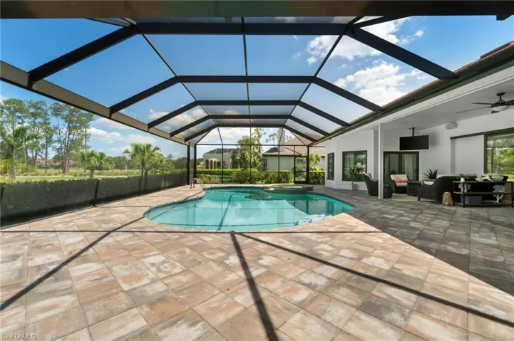Integrated pool / hot tub featuring a sunroom, an outdoor lounge area, a patio, and glass enclosure