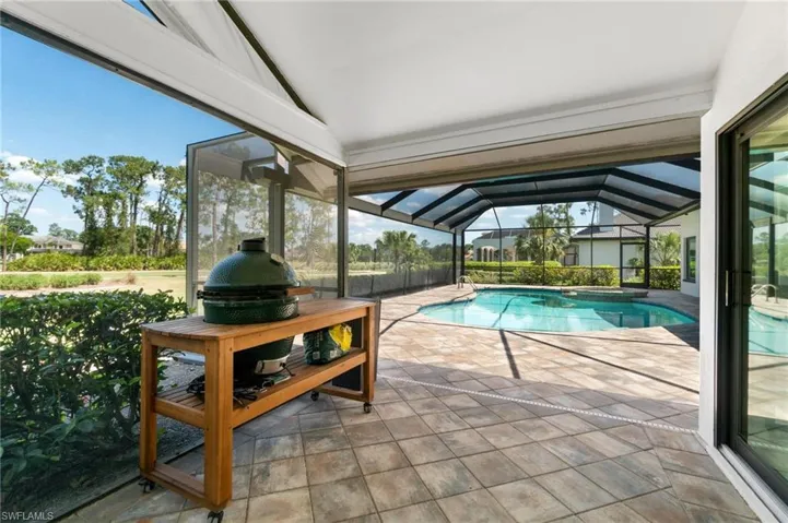 Swimming pool featuring a sunroom, glass enclosure, and a patio
