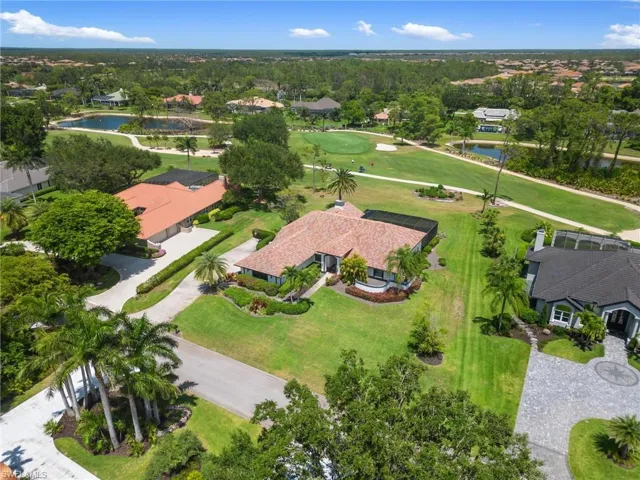 Aerial perspective of suburban area featuring a nearby body of water and a golf club