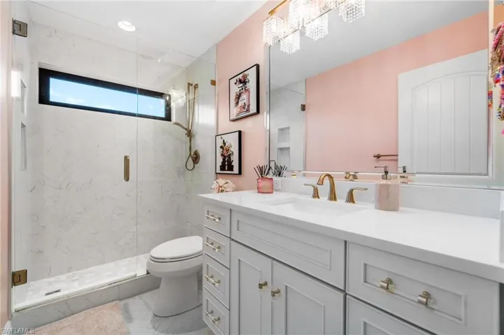 Bathroom featuring vanity and a marble finish shower
