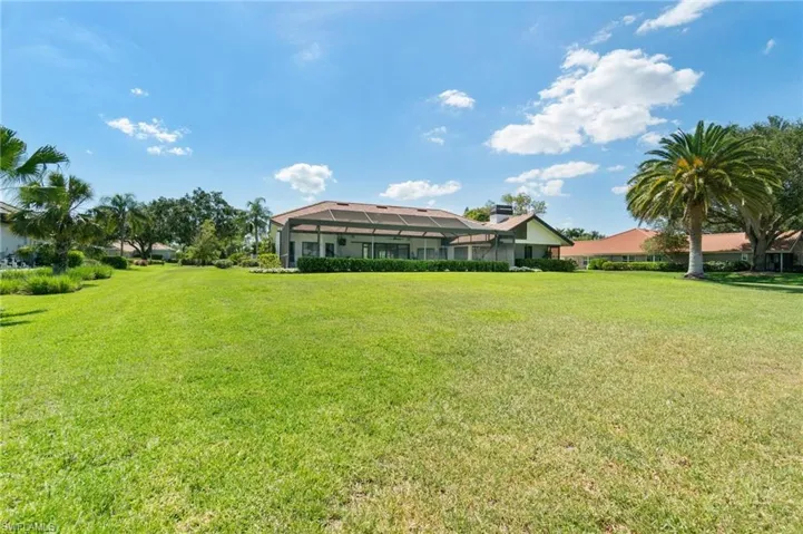View of grassy yard featuring a sunroom and a lanai