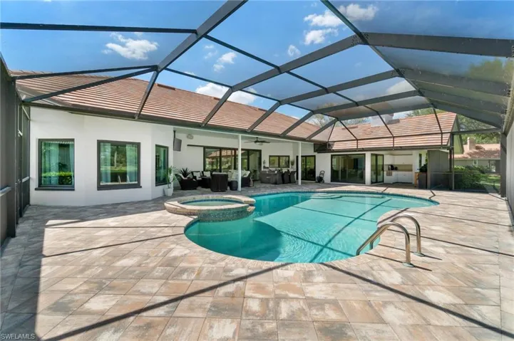 Relaxing pool / spa featuring a sunroom, glass enclosure, a patio area, and outdoor furniture