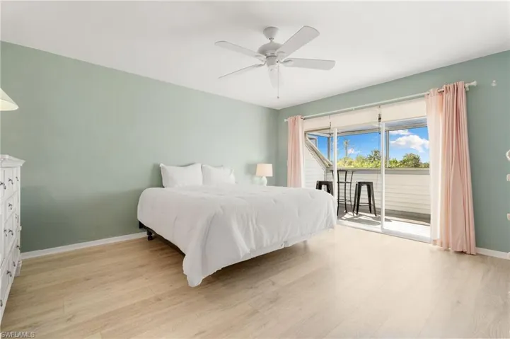 Bedroom featuring access to exterior, light wood-type flooring, and ceiling fan