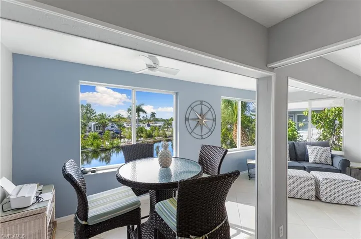 Dining room featuring light tile patterned floors, healthy amount of natural light, a water view, and a ceiling fan
