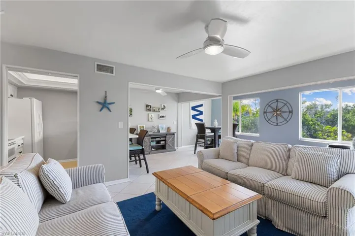 Living room with light tile patterned flooring and a ceiling fan