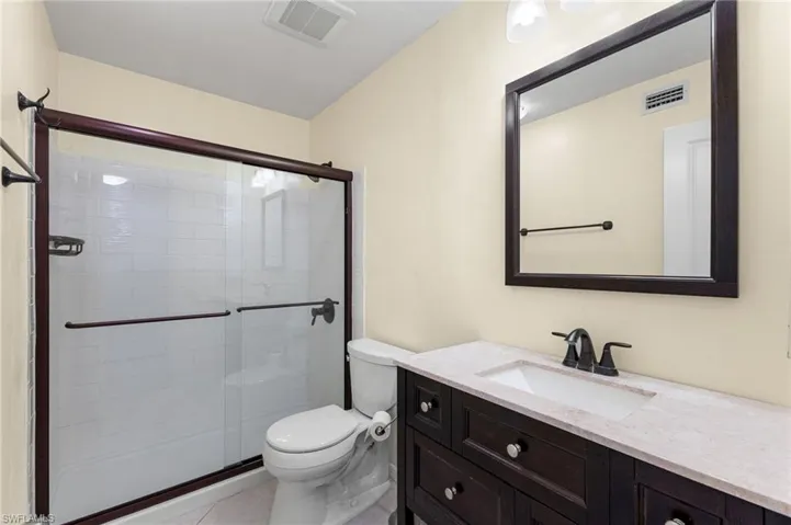Bathroom with vanity, a shower stall, and light tile patterned floors