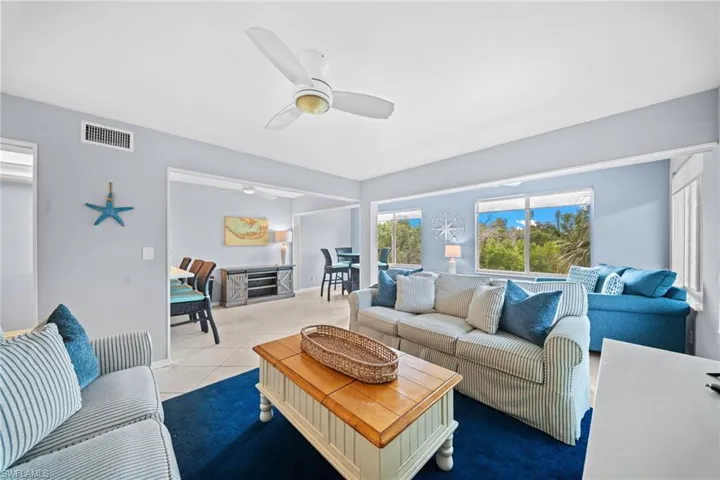 Open-concept living area with tiled flooring, neutral wall tones, and recessed lighting