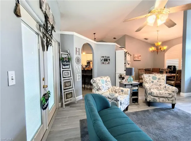 Front Sitting room featuring wood-type tile flooring and ceiling fan with notable chandelier