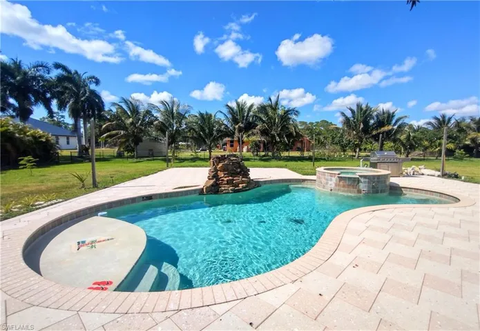 View of swimming pool with a lawn, an in ground hot tub, and a patio