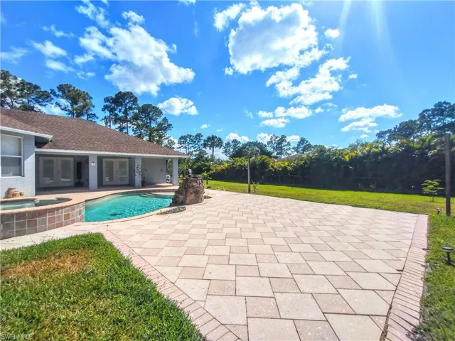 View of swimming pool with a patio and an in ground hot tub