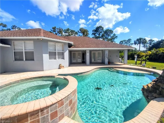 View of pool with a patio area and an in ground hot tub