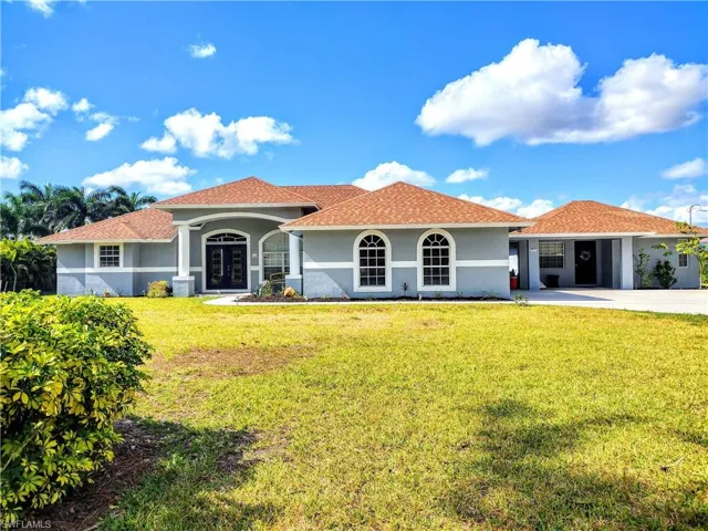 Mediterranean / spanish home featuring a garage and a front lawn