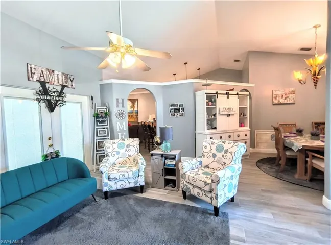 Sitting room with hardwood / wood-style floors, ceiling fan, and lofted ceiling