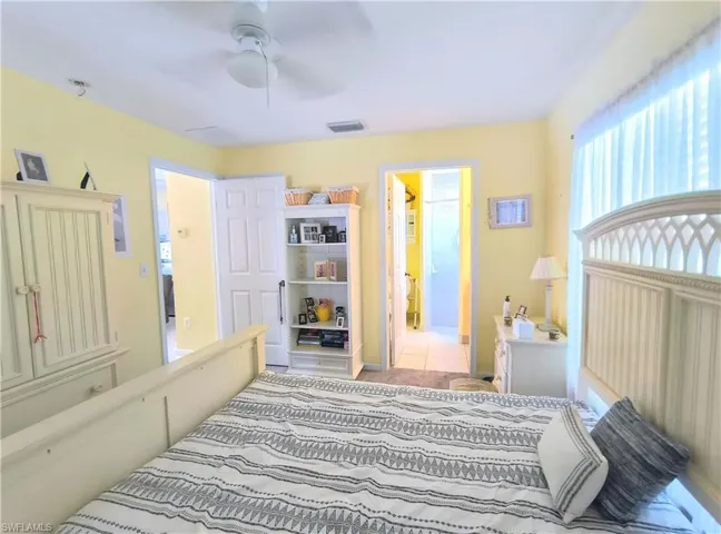 Tiled bedroom featuring ceiling fan