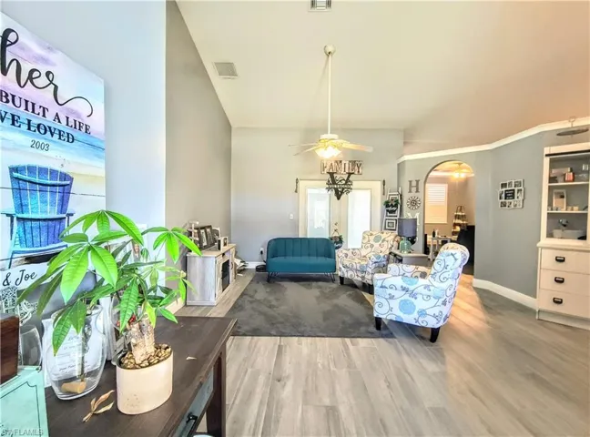 Sitting room featuring ceiling fan, french doors, and wood tile flooring