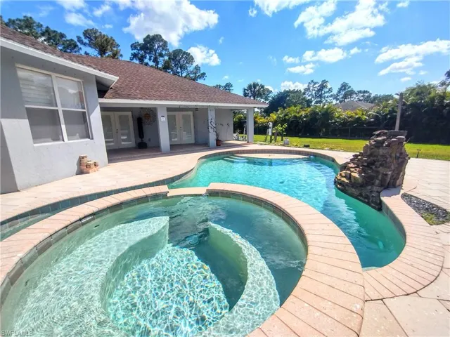 View of swimming pool with a patio and an in ground hot tub
