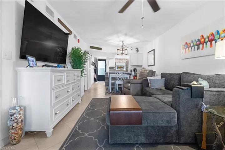 Living room featuring light tile patterned flooring and a ceiling fan