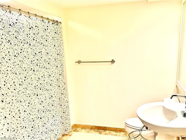 Full bathroom featuring a shower stall and tile patterned floors