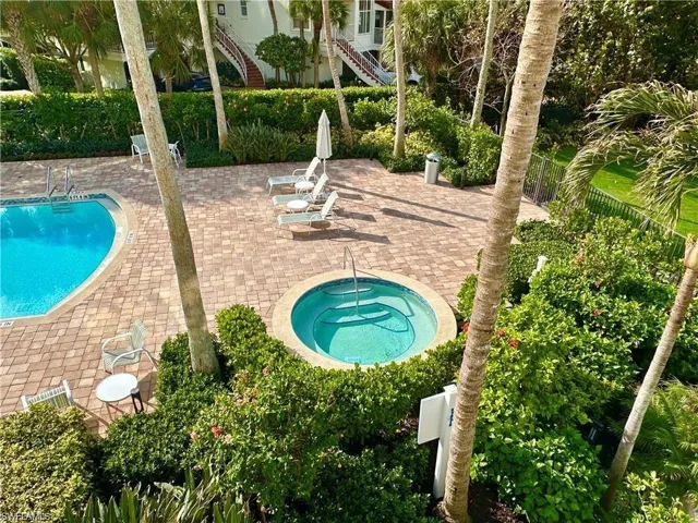 Community pool featuring a patio, a community hot tub, and stairway