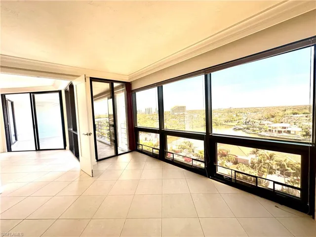 Unfurnished sunroom featuring a wall of windows and tile patterned flooring