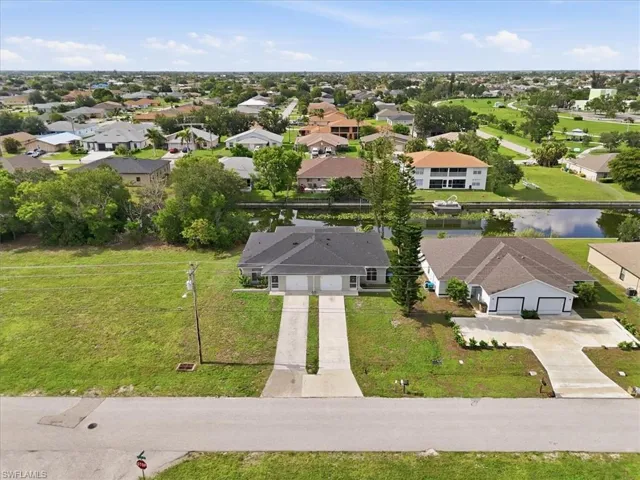 Duplex property featuring a dual-car garage and two separate driveways