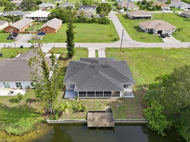Waterfront property featuring a private boat dock, screened porch, and a two-car driveway