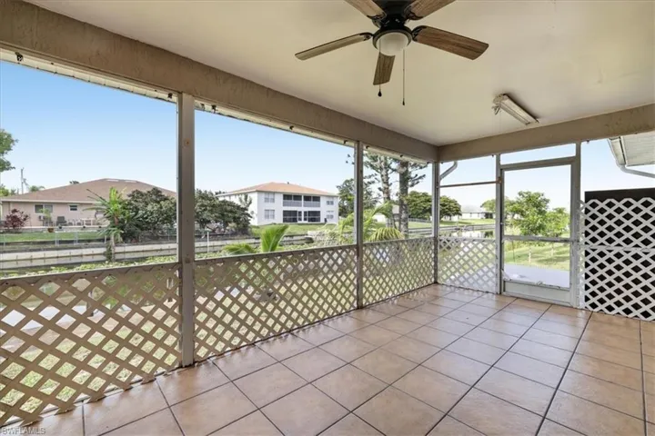 Screened lanai featuring large format tile flooring, a ceiling fan, and direct access to the exterior