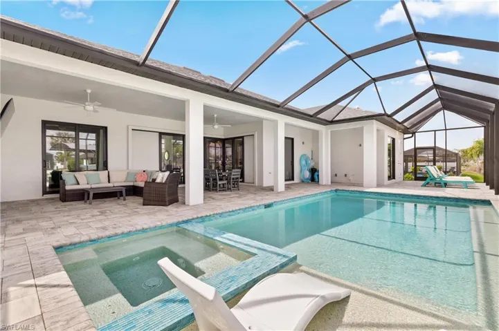 Relaxing pool / spa with a sunroom, a patio, glass enclosure, and outdoor lounge area