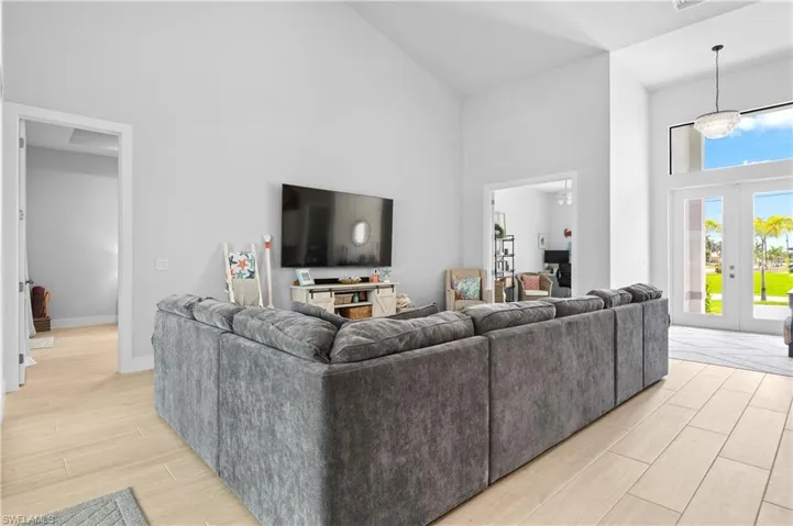 Living area featuring french doors, lofted ceiling, and wood finish floors