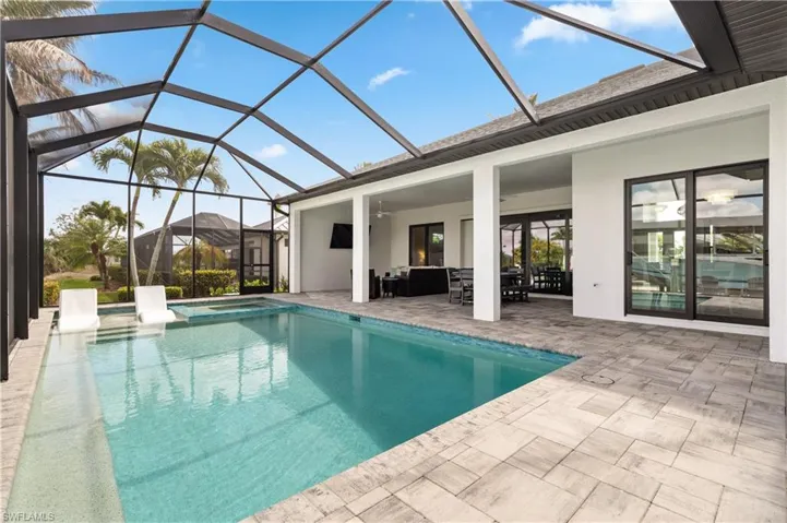 Integrated pool / spa featuring a sunroom, glass enclosure, a patio, and an outdoor lounge area