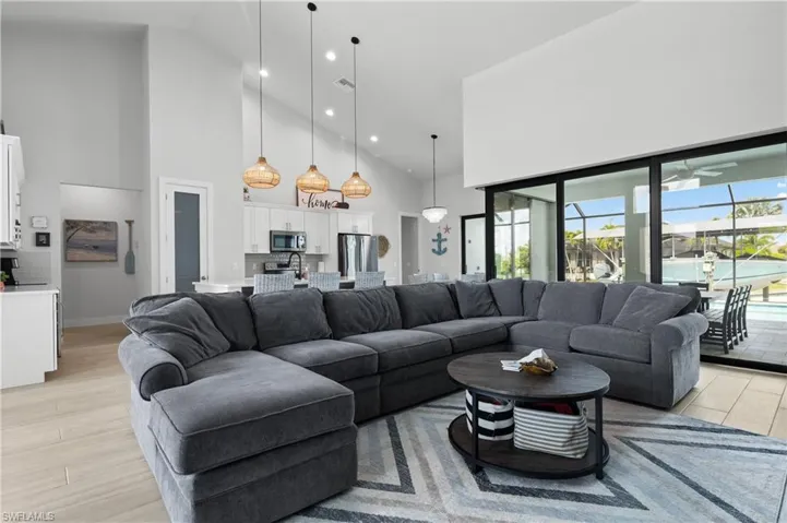 Living area with light wood-style floors, plenty of natural light, vaulted ceiling, and recessed lighting