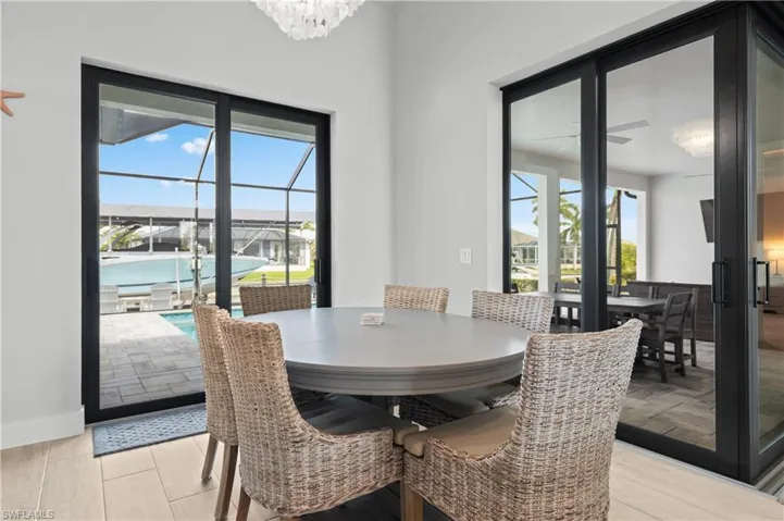 Dining area with a sunroom, light wood-style floors, plenty of natural light, and suspended lighting