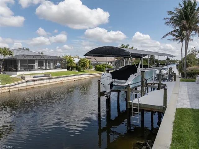 Dock with boat lift, a water view, and a sunroom