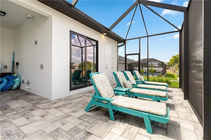 View of patio featuring a sunroom and glass enclosure