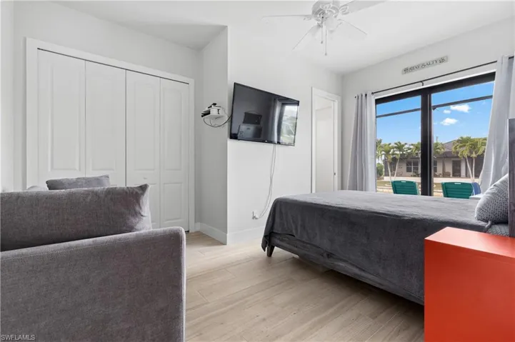 Bedroom with light wood-type flooring, access to exterior, a closet, and a ceiling fan