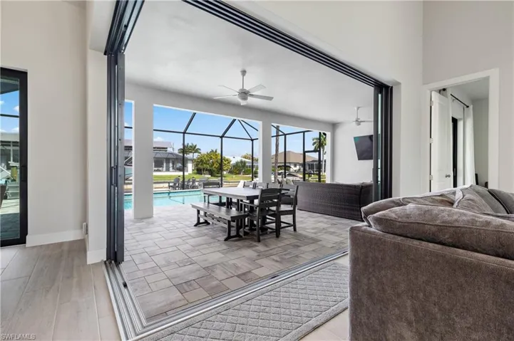 View of patio / terrace featuring a ceiling fan, a sunroom, an outdoor living / dining area, a lanai, and an outdoor pool