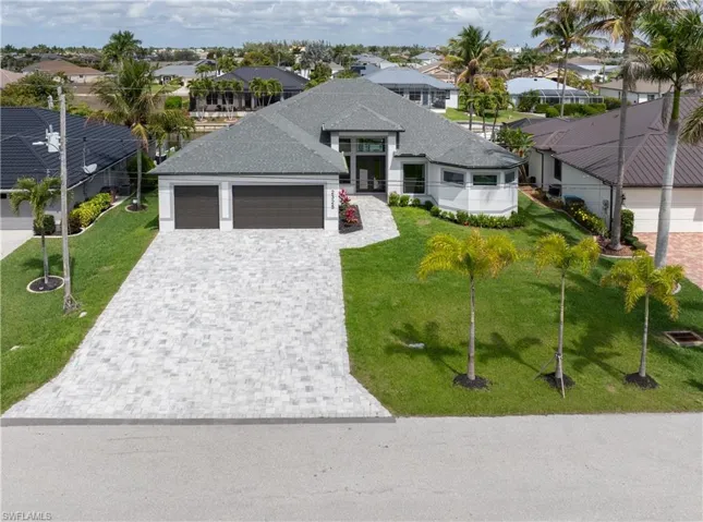 View of front facade with an attached garage, a residential view, decorative driveway, and roof with shingles