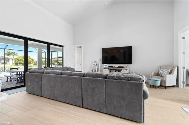 Living room with vaulted ceiling and light wood-style floors