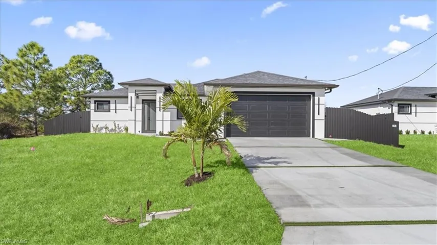 View of front facade with concrete driveway, stucco siding, and an attached garage
